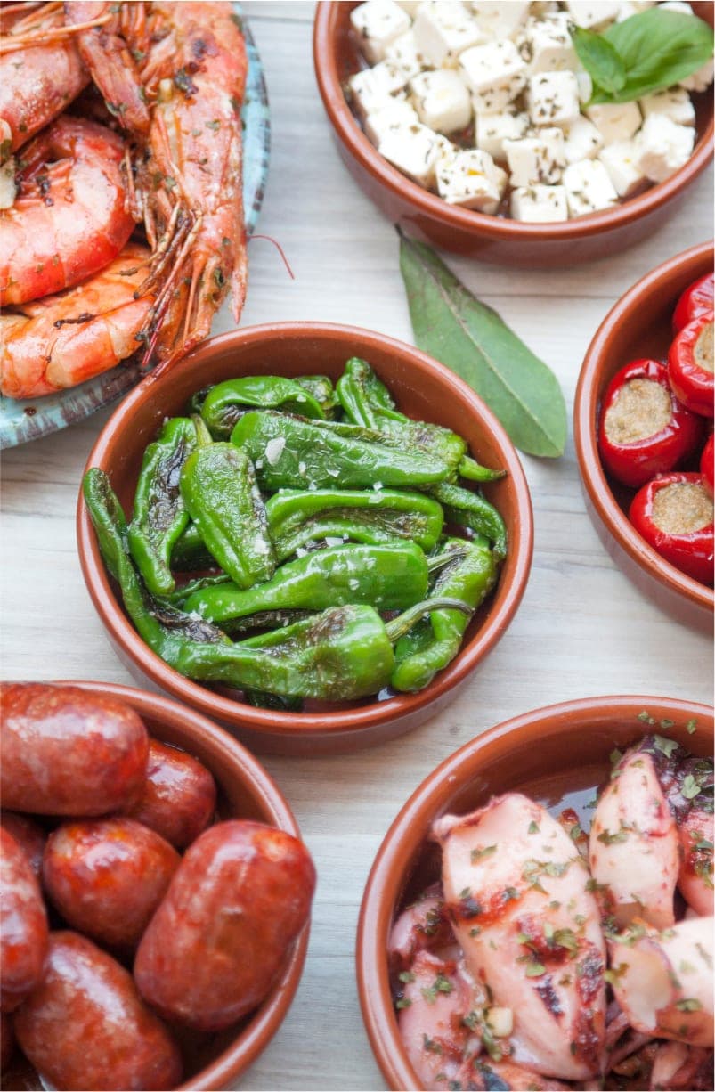 Tapas-skåle med grøntsager, rejer og oliven
